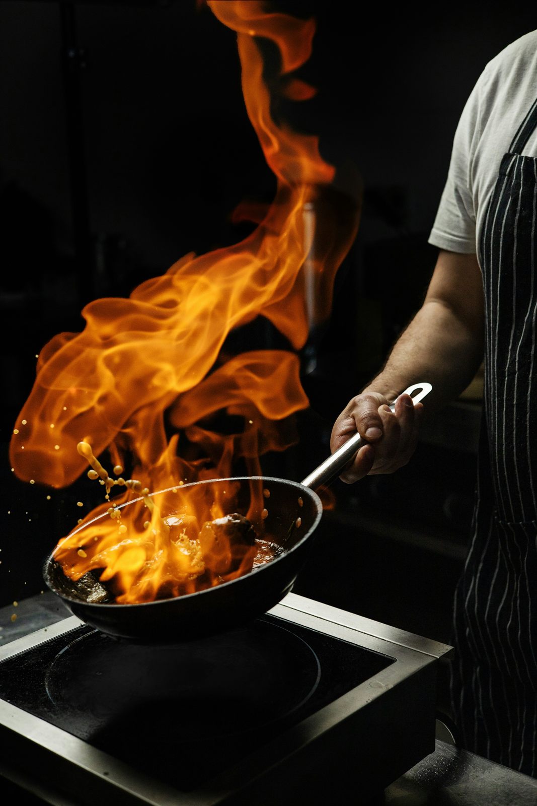 Flambage d'une pièce de viande à la poêle dans la cuisine du restaurant