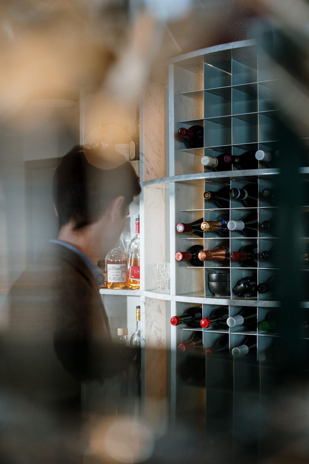 Casiers à bouteilles en marbre de la cave à vins, aperçus depuis la salle